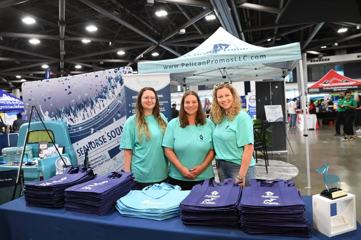Southern View Media and Pelican Promos team members at a tote bag giveaway table